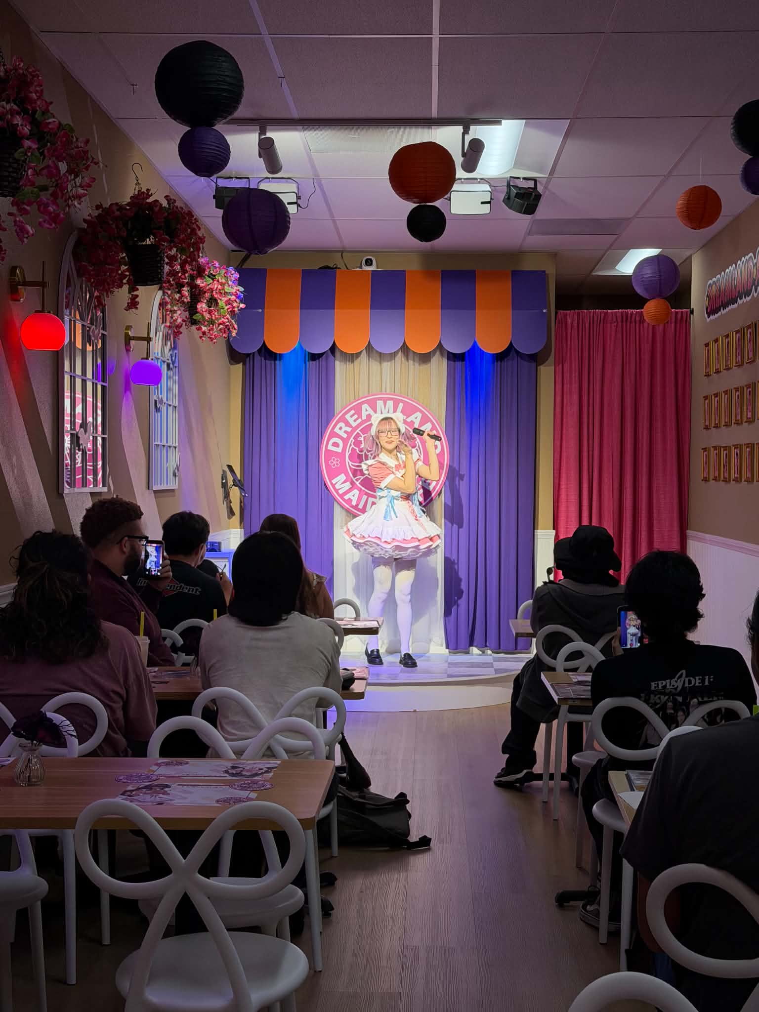 Dreamland maid performing on the café stage before guests